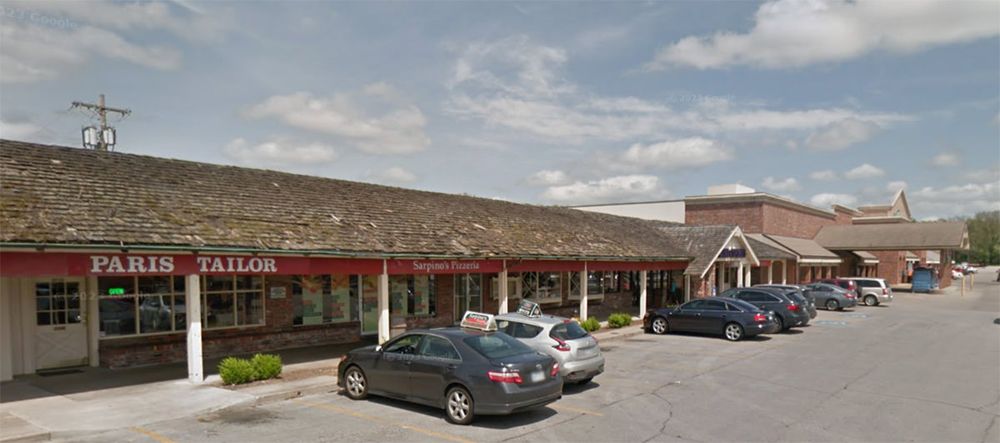 Ranch Mart North before redevelopment, showing the original dated ranch-style storefronts and shingled overhang